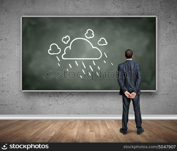 Business education. Rear view of businessman looking at chalkboard