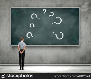 Business education. Rear view of businesswoman looking at chalkboard