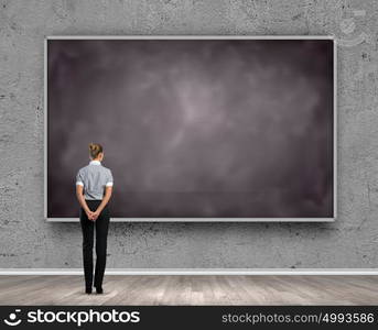 Business education. Rear view of businesswoman looking at chalkboard