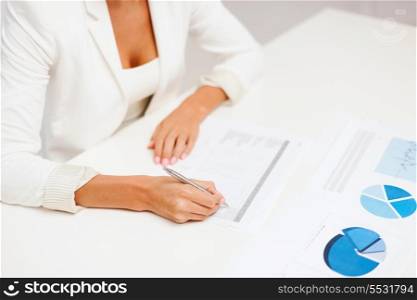 business, education, school, documents, people concept - businesswoman or student working with graphs in office