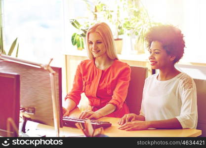 business, education, startup and people concept - happy women or students with computer in office