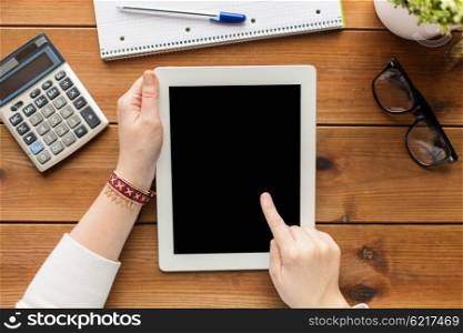 business, education, technology and people concept - close up of woman with blank tablet pc computer screen, calculator and eyeglasses on wooden table