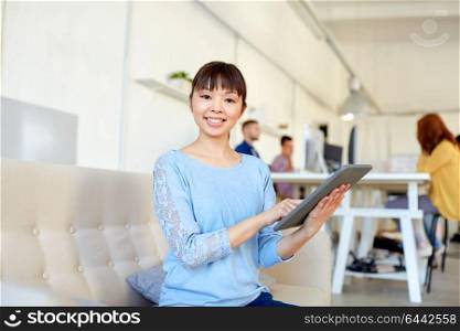 business, education, technology and people concept - happy young asian woman with tablet pc computer working at office. happy asian woman with tablet pc working at office