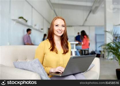 business, education, technology and people concept - happy young woman with laptop computer working at office. happy woman with laptop working at office