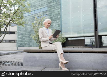 business, education, technology and people concept - smiling businesswoman working with tablet pc computer on city street