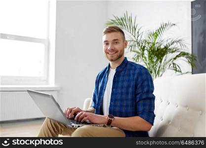 business, education, technology and people concept - young man with laptop computer working at office. man with laptop working at office. man with laptop working at office