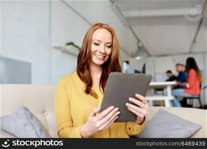 business, education, technology and people concept - young redhead woman with tablet pc computer working at office. redhead woman with tablet pc working at office