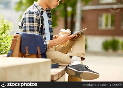 business, education, technology, communication and people concept - close up of creative or hipster man with tablet pc computer drinking coffee from paper cup and sitting on city street bench