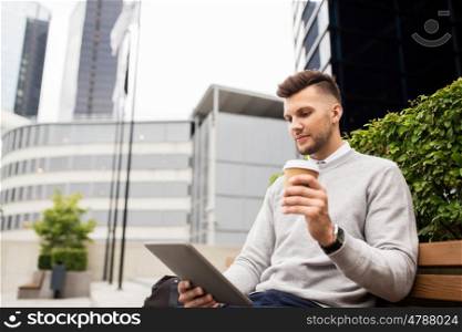 business, education, technology, communication and people concept - creative man with tablet pc computer drinking coffee from paper cup and sitting on city street bench