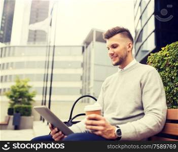 business, education, technology, communication and people concept - creative man with tablet pc computer drinking coffee from paper cup and sitting on city street bench. man with tablet pc and coffee on city street bench