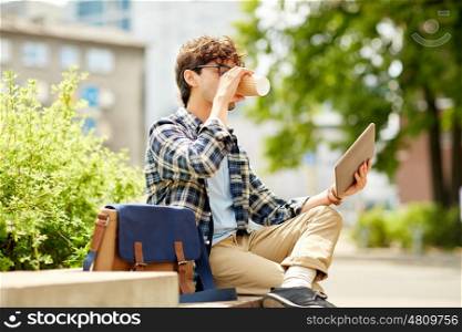 business, education, technology, communication and people concept - creative or hipster man with tablet pc computer drinking coffee from paper cup and sitting on city street bench