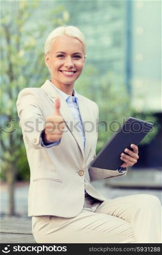 business, education, technology, gesture and people concept - smiling businesswoman working with tablet pc computer showing thumbs up on city street