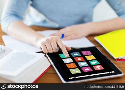 business, education, technology, media and people concept - close up of student woman with menu icons on tablet pc computer screen and notebook at home