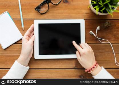 business, education, technology, people and advertisement concept - close up of woman with blank tablet pc computer screen on wooden table