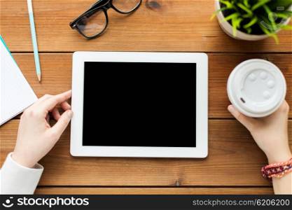 business, education, technology, people and advertisement concept - close up of woman with blank tablet pc computer screen and coffee on wooden table