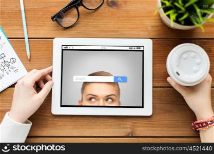 business, education, technology, people and internet concept - close up of woman with internet browser search bar on tablet pc computer screen and coffee on wooden table