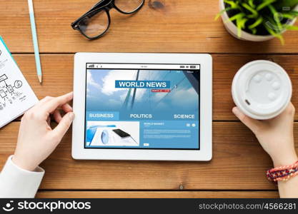 business, education, technology, people and mass media concept - close up of woman with world news on tablet pc computer screen and coffee on wooden table