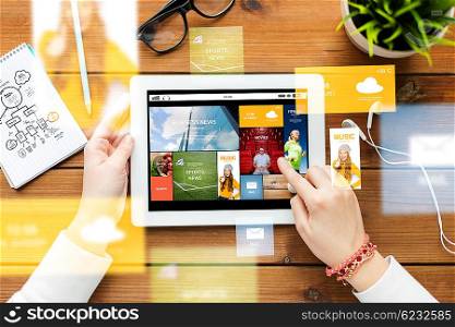 business, education, technology, people and mass media concept - close up of woman with internet news application on tablet pc computer screen on wooden table
