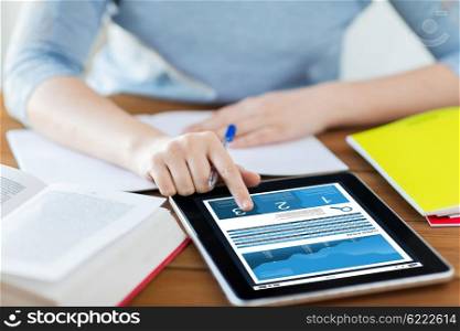 business, education, technology, statistics and people concept - close up of student woman with chart on tablet pc computer and notebook at home