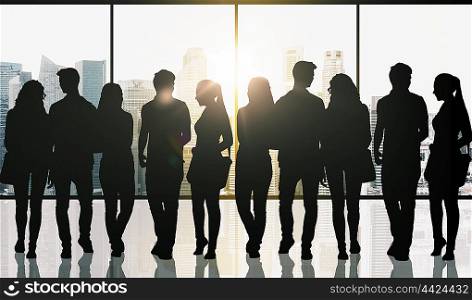 business, education, travel and people concept - students silhouettes with bags over singapore city skyscrapers view and sun light background
