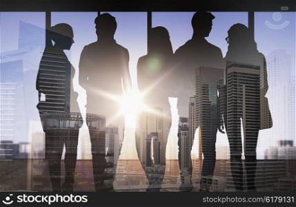 business, education, travel, tourism and people concept - people silhouettes over double exposure office and city background