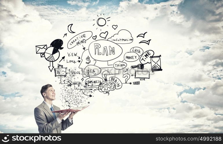 Business education. Young businessman with opened book in hands and business sketches