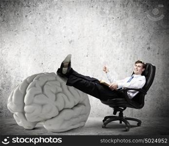 Business education. Young handsome businessman sitting in chair and reading book