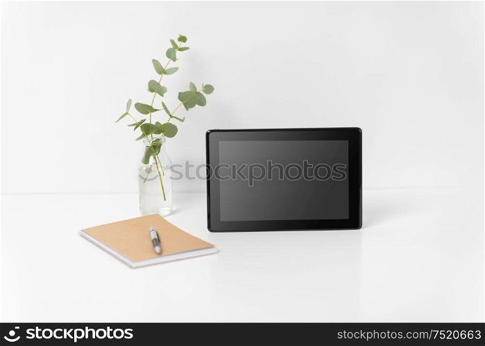 business, electronics and interior concept - tablet pc computer with black screen on white office table. tablet pc with black screen on white office table