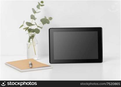business, electronics and interior concept - tablet pc computer with black screen on white office table. tablet pc with black screen on white office table