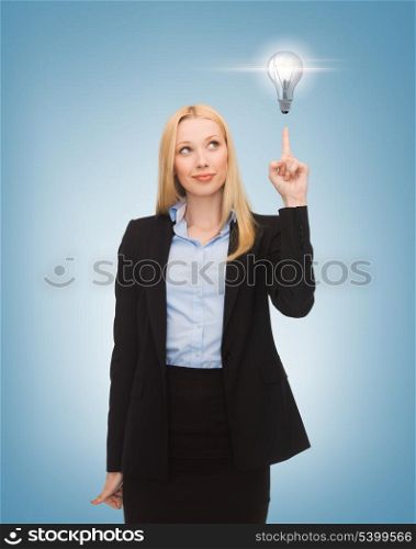 business, energy and environment concept - woman pointing at light bulb