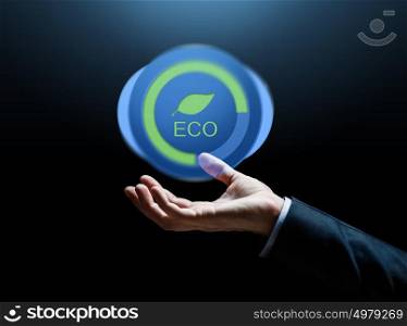 business, environment, ecology and people concept - close up of businessman hand with eco icon over dark background. close up of businessman hand with eco icon