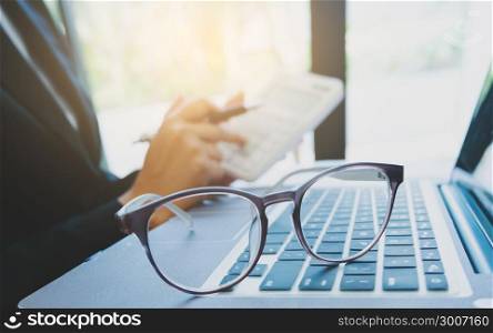 business executive calculating a data information, selective focus on eyeglasses