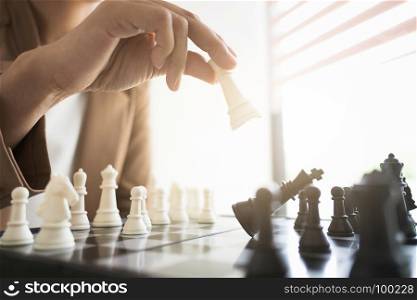 business executive playing chess on board in office, strategy and competition concept