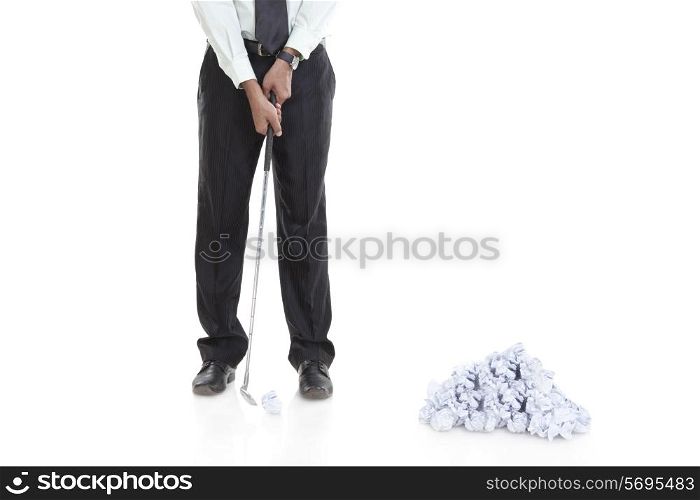 Business executive playing golf with paper ball