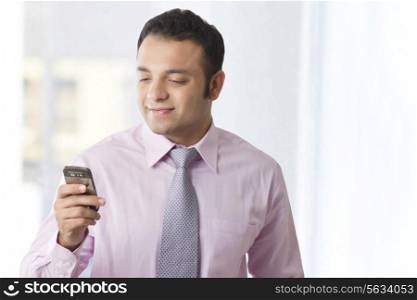 Business executive reading an sms on a mobile phone