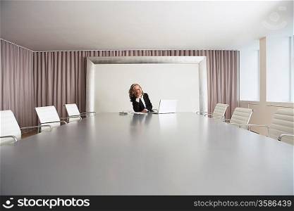Business Executive Using Laptop in Conference Room