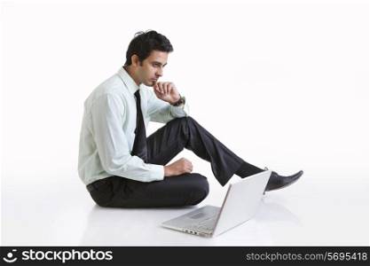 Business executive with laptop thinking