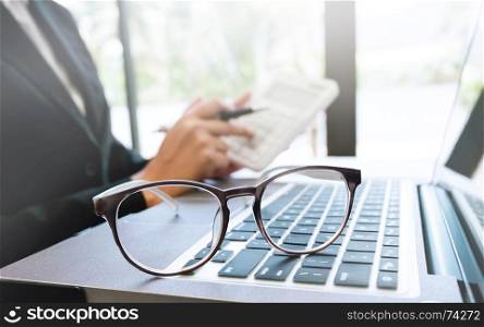 business executive working on caculator selective focus on eyeglasses