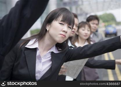 Business executives hailing a taxi at an airport