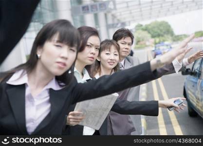 Business executives hailing a taxi at an airport