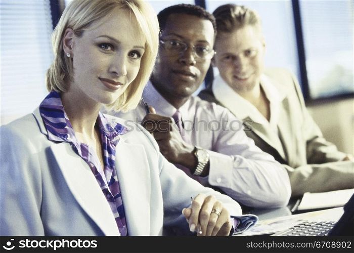 Business executives in an office looking at camera
