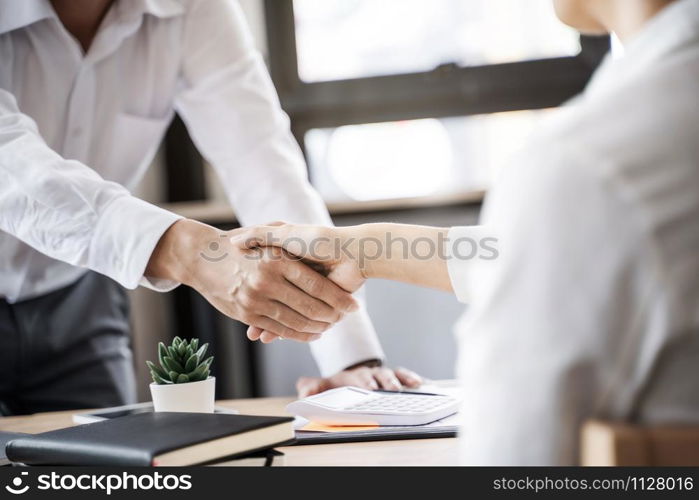 Business executives shaking hands after meeting at office, colleagues management