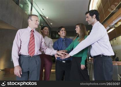 Business executives stacking hands at an airport