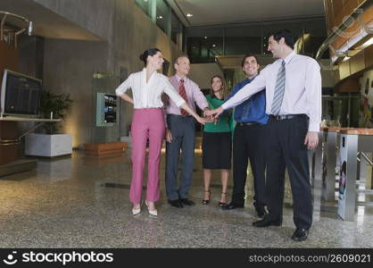Business executives stacking hands at an airport