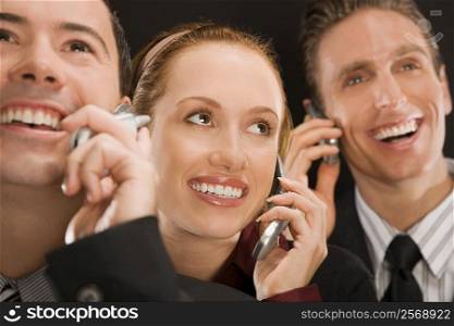 Business executives talking on mobile phones and smiling