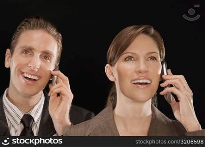 Business executives talking on mobile phones and smiling