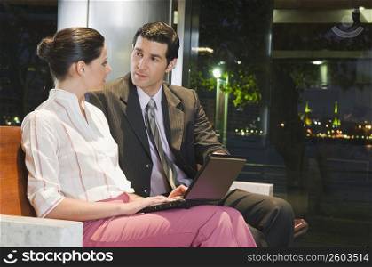 Business executives working on a laptop at an airport lounge