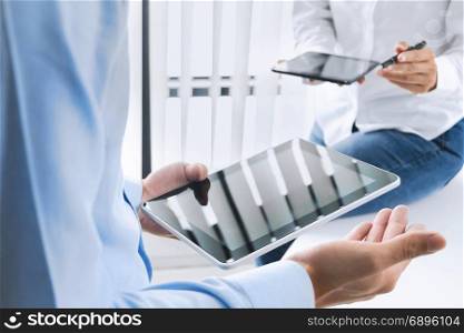 Business executives working together and using digital tablet at a workplace