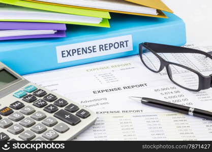 Business expense report binder with financial documents and calculator