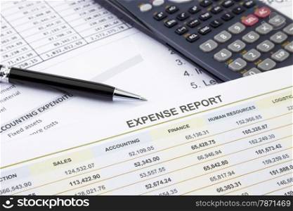 Business expense report with pen and calculator